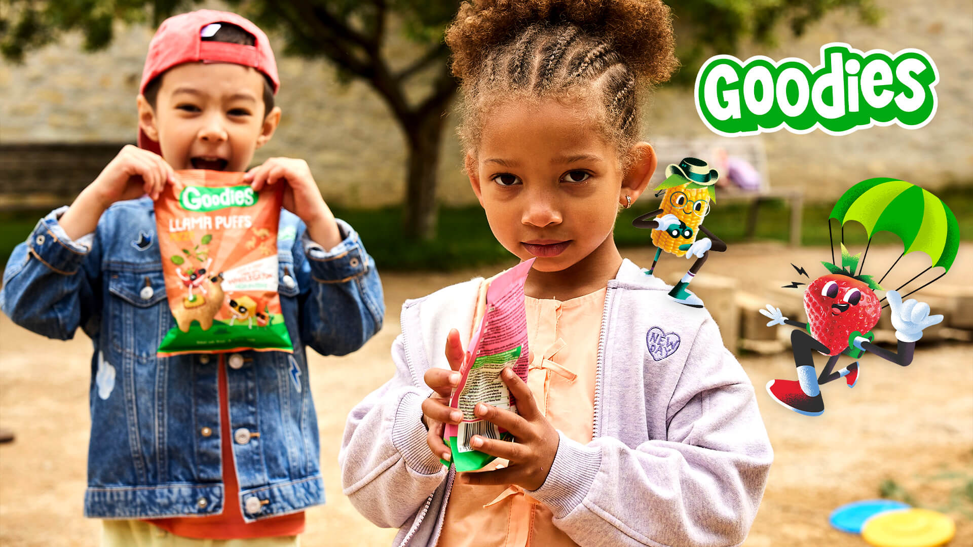 Two children enjoy Goodies brand snacks in a vibrant outdoor playground setting, with the Goodies logo and animated snack characters adding a playful touch